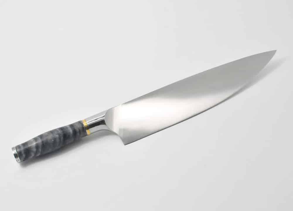 https://mizenplace.com/wp-content/uploads/2021/04/10-Inch-Chef-Knife-with-a-Ancient-Wood-Vein-Marble-Handle-a-Champagne-Cubic-Zirconia-Stone-at-the-Back-of-the-Knife-and-Brass-and-Stainless-Steel-Decorative-Rings.jpg