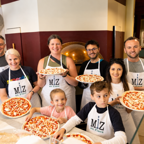 Group pizza cooking with updated apron logos