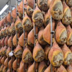 Rows of prosciutto in curing room